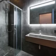 Grey tile with backlit bathroom mirror